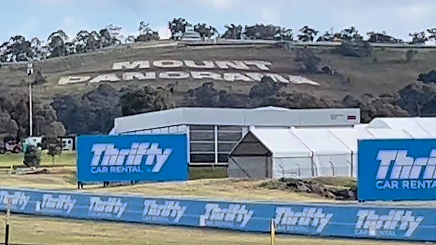 The words MOUNT PANORAMA mown into the grass of the hillside above the circuit, with marquees and sponsor hoardings below