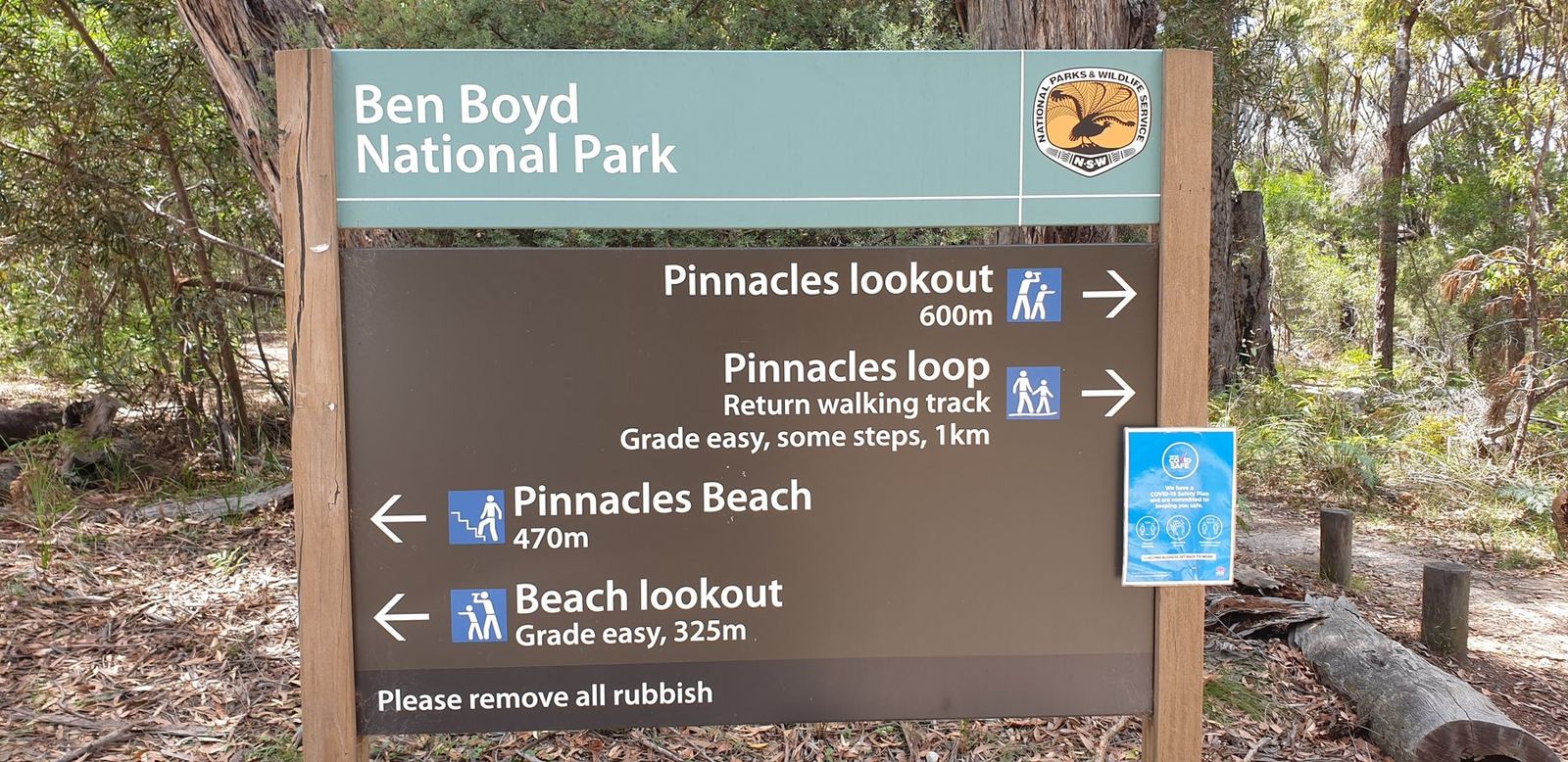 A brown national park signpost reading Ben Boyd National Park with arrows to Pinnacles lookout 600m, Pinnacles loop return walking track grade easy some steps 1km, Pinnacles Beach 470m and Beach lookout 325m