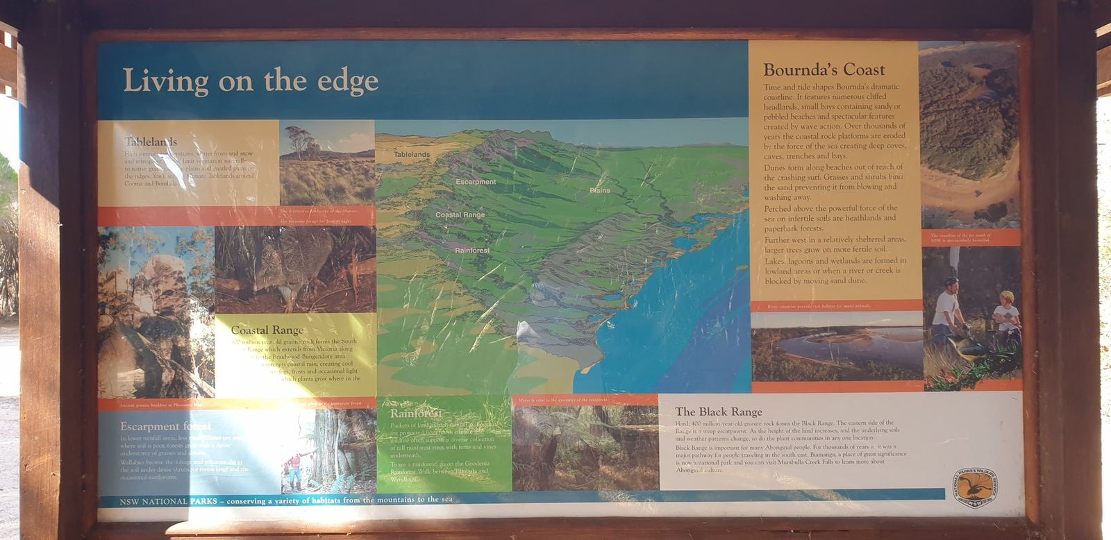 A second NPWS interpretive panel headed Living on the edge, with a map of Bournda's coast and the Bega Valley behind it