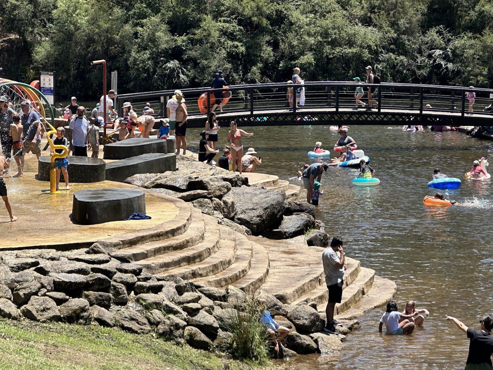 The Bright River Pool seen from the path above, the weir and the swimming reach of the Ovens River with people along both banks