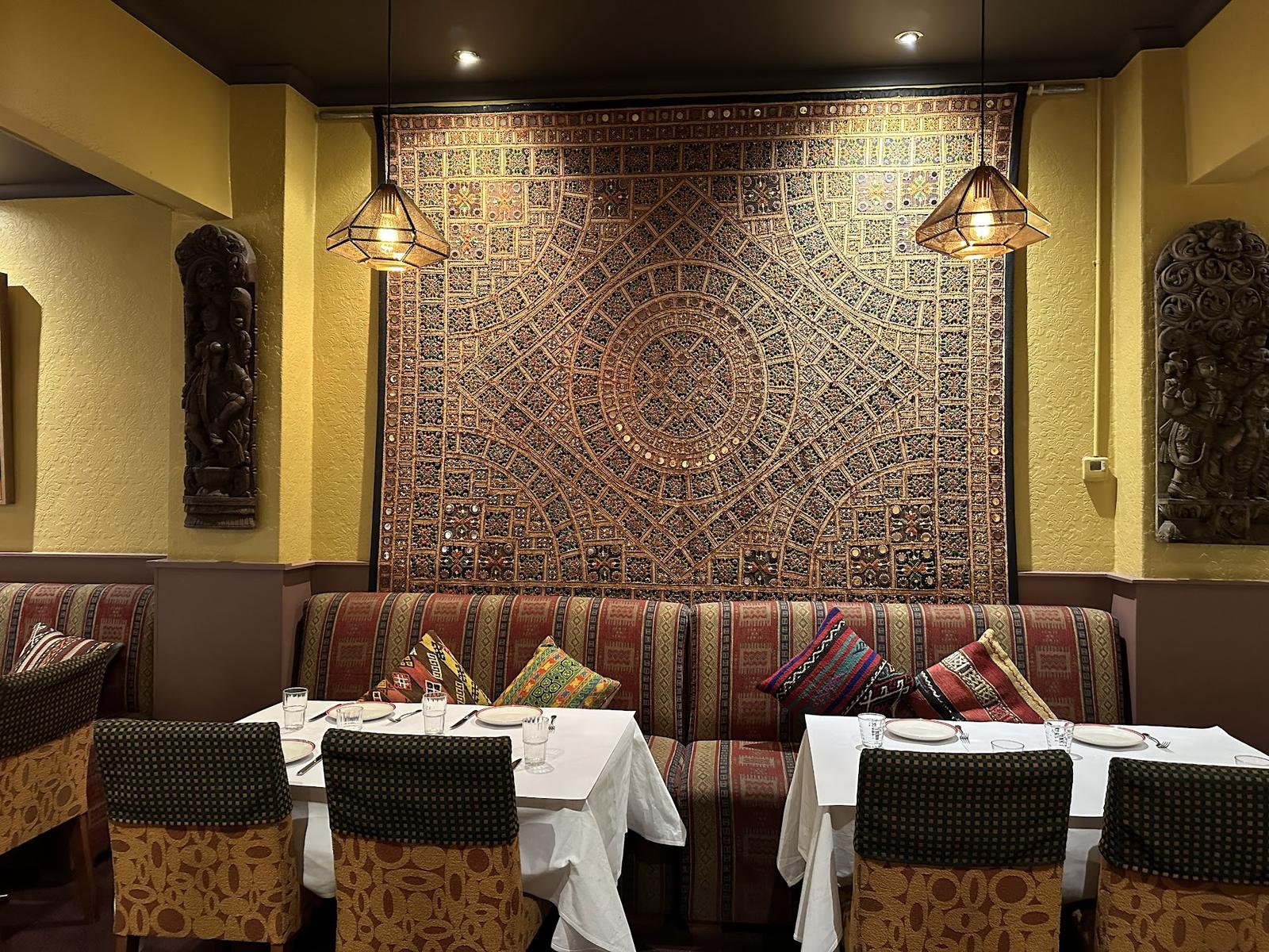 A large carved and inlaid wooden panel mounted on the restaurant wall above a bench seat