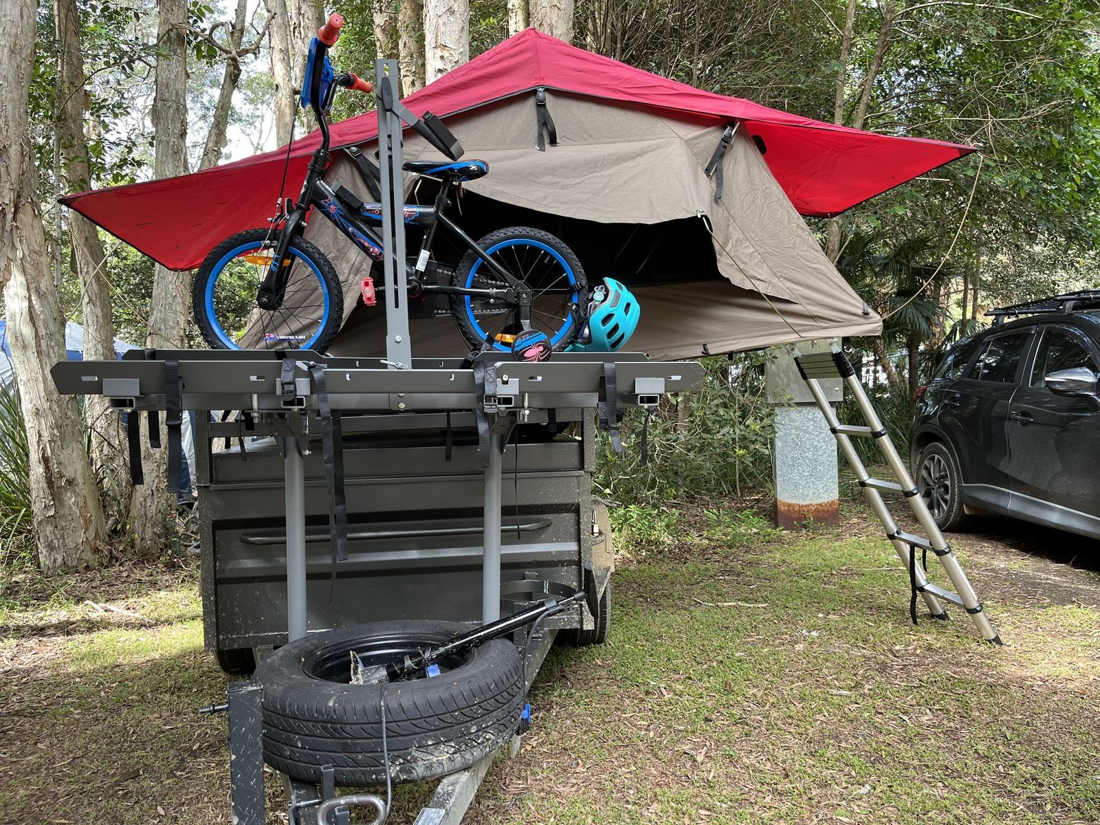 The same rig from a little further back, showing the ladder, the spare wheel and the car parked behind