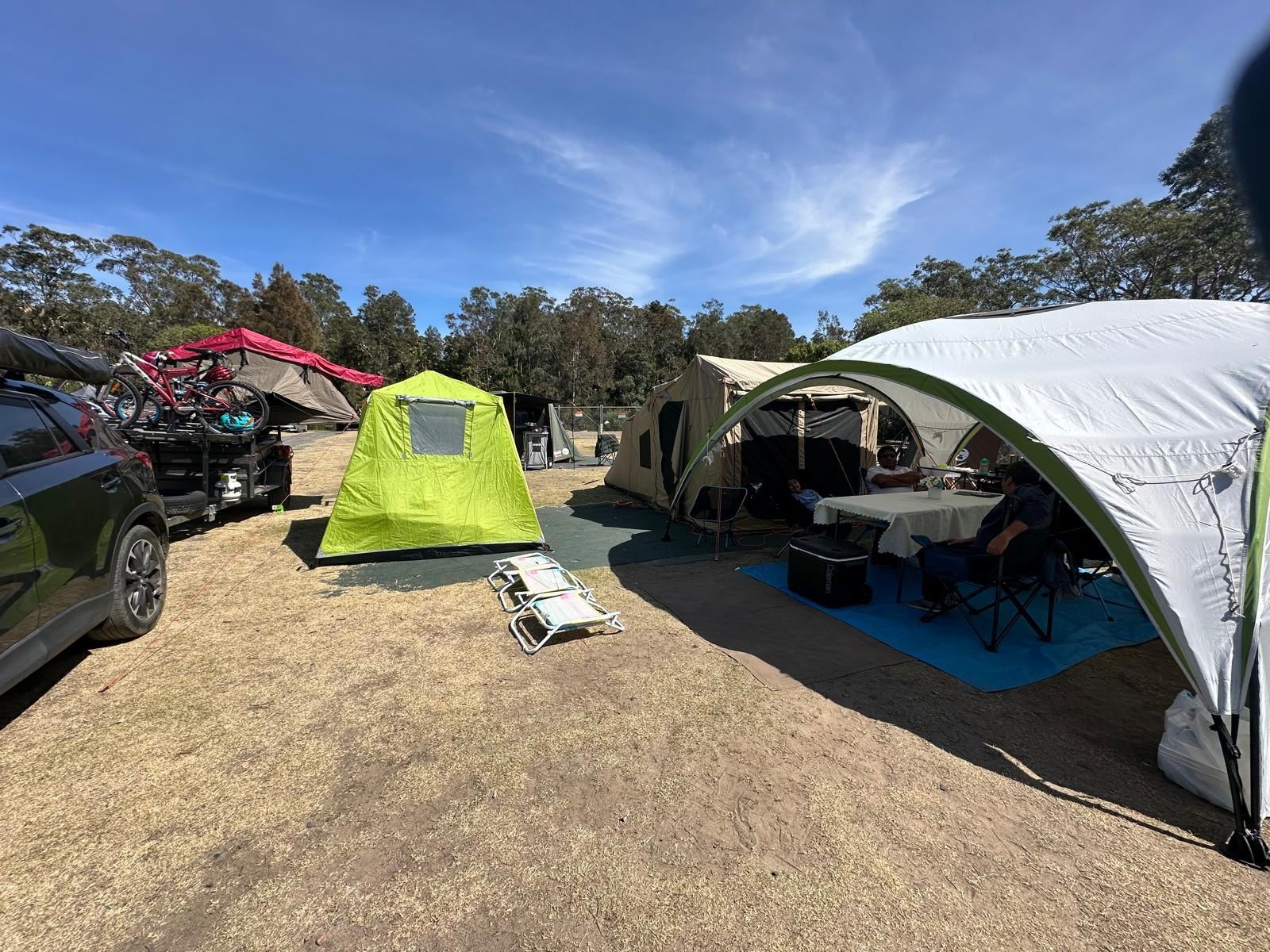 The same camp from the other end, the car with bikes on the rack parked alongside the tents